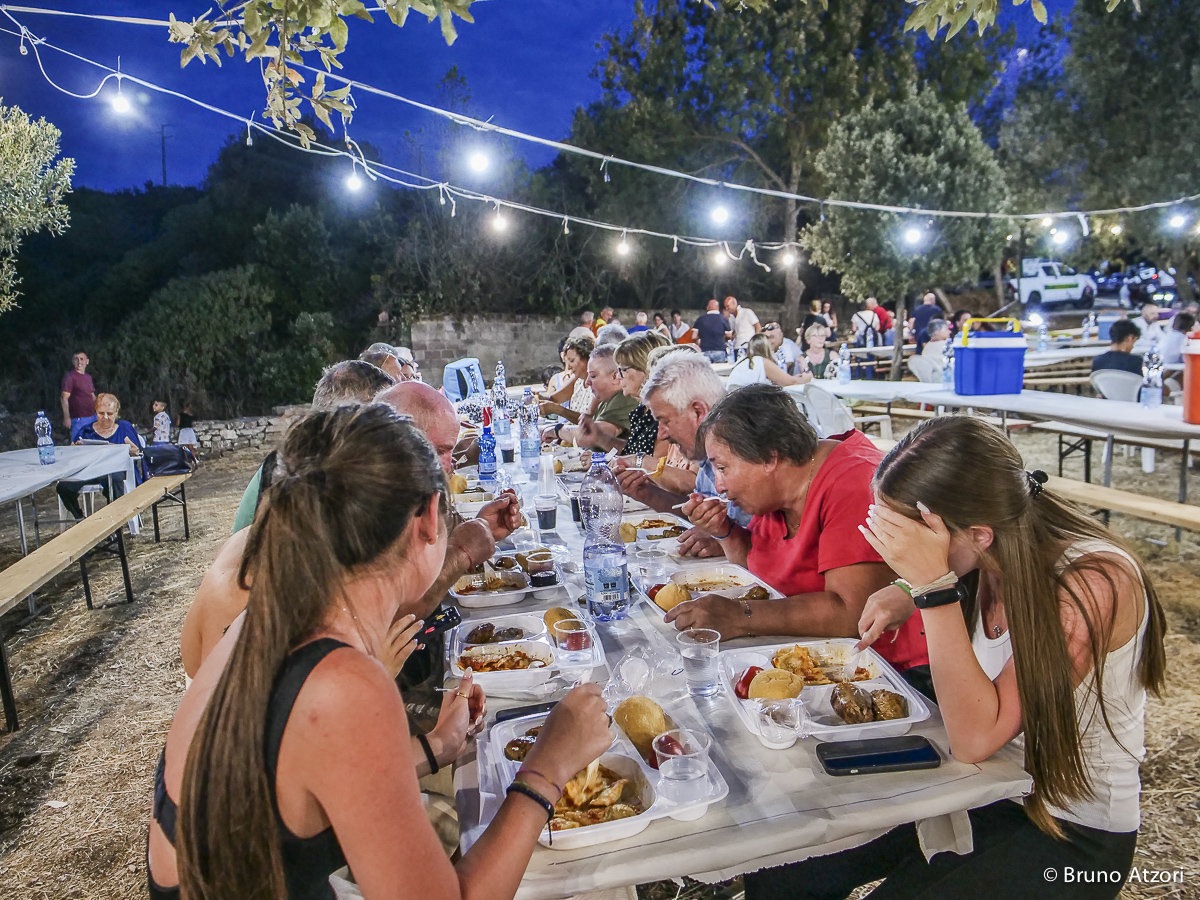 CENA – PANORAMICA DEI TAVOLI COMUNI
Dalla vigna alla tavola: la giornata prosegue con la cena comunitaria organizzata dalla Pro Loco di Ardauli in occasione della Sagra di San Quirico.