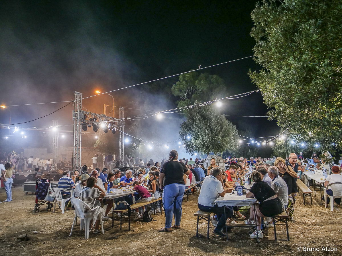 CENA – PANORAMICA DEI TAVOLI COMUNI
Dalla vigna alla tavola: la giornata prosegue con la cena comunitaria organizzata dalla Pro Loco di Ardauli in occasione della Sagra di San Quirico.