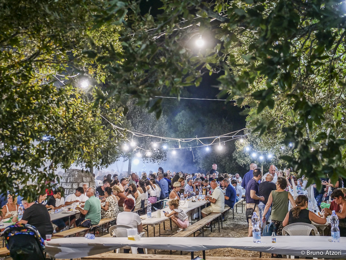 CENA – PANORAMICA DEI TAVOLI COMUNI
Dalla vigna alla tavola: la giornata prosegue con la cena comunitaria organizzata dalla Pro Loco di Ardauli in occasione della Sagra di San Quirico.